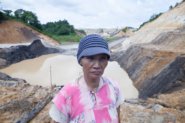A GSM plaintiff and a farmer stand on the edge of her mined land in Samarinda -  Armin Hari