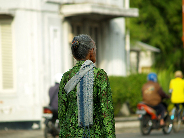 An old woman walks down the street.