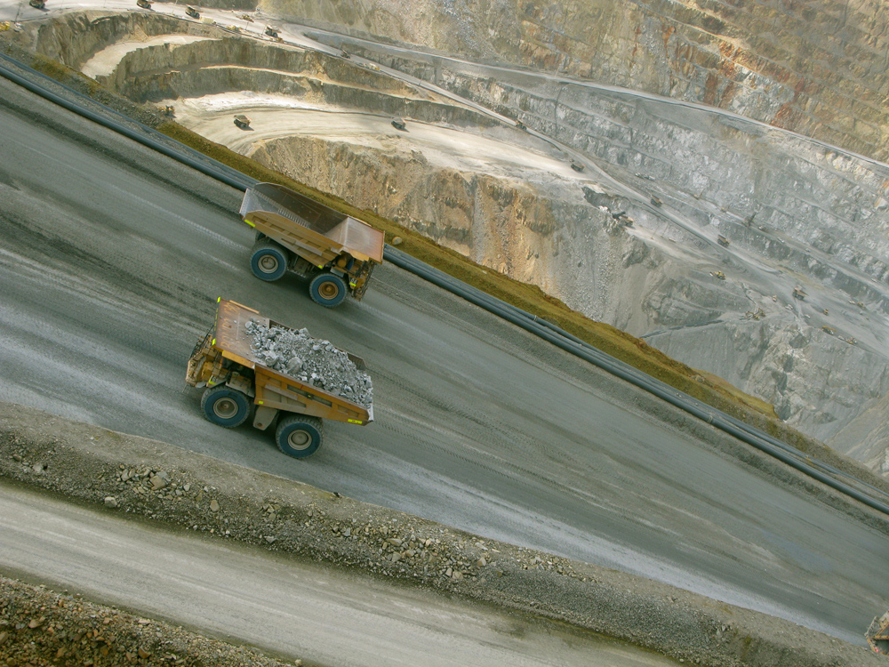 Two carts rest on a mining site path. The photo is taken at an angle where the path appears to be going down from left to right.