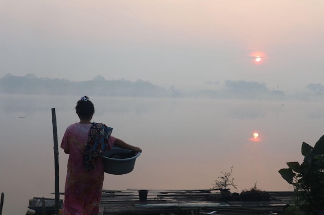 A woman preparing to do the laundry amid the haze in Perigi Village/Hanina Naura Fadhila