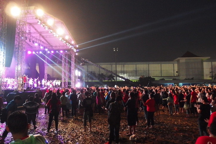 Audience members clap joyously despite the mud and rain - CY Hoon Audience members clap joyously despite the mud and rain - CY Hoon